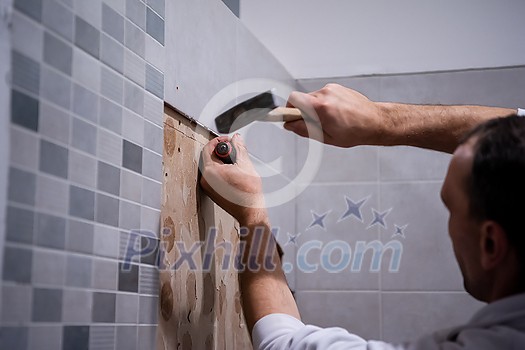 professional worker remove demolish old tiles in a bathroom with hammer and chisel professional worker remove demolish old tiles in a bathroom with hammer and chisel