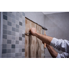 professional worker remove demolish old tiles in a bathroom with hammer and chisel