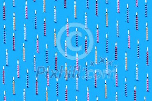 Horizontal congratulation composition from multicolored burning bithday candles for sweet dessert and cakes on a blue background. Birthday party card. Horizontal congratulation composition from multicolored burning bithday candles for sweet dessert and cakes on a blue background. Birthday party card.