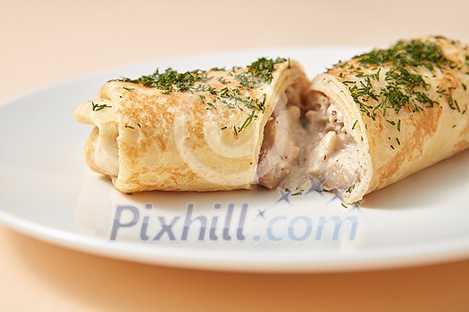 Homemade freshly cooked delicious roll pancake with filling from chicken and mushroom on a ceramic plate on a pastel beige background, copy space. Homemade freshly cooked delicious roll pancake with filling from chicken and mushroom on a ceramic plate on a pastel beige background, copy space.