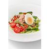 Freshly cooked delicious homemade tuna salad with fresh natural organic vegetables, tomatoes, spinach and half of egg on a white ceramic plate, copy space.
