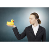 Young businesswoman holding yellow rubber duck toy in palm