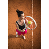 Top view of attractive young woman tennis player serving on a clay tennis court. Interesting POV shot -  sporty girl during tennis training in the club