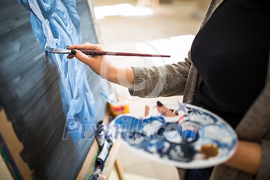 Palette and paint brush in artist hands. Artist paints oil picture with paint brush in hand palette close-up. Artist painting holding palette and paint brush in hand. Artists paintbrush with palette. Palette and paint brush in artist hands. Artist paints oil picture with paint brush in hand palette close-up. Artist painting holding palette and paint brush in hand. Artists paintbrush with palette.