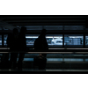 Airport rush: people with their suitcases walking along a corridor (motion blurred image; color toned image)