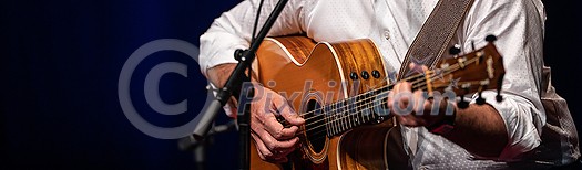 Man playing a guitar on stage (shallow DOF; color toned image) Man playing a guitar on stage (shallow DOF; color toned image)