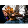 Man playing a guitar on stage (shallow DOF; color toned image)