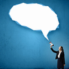 Young businesswoman with megaphone in hand and speech bubble above