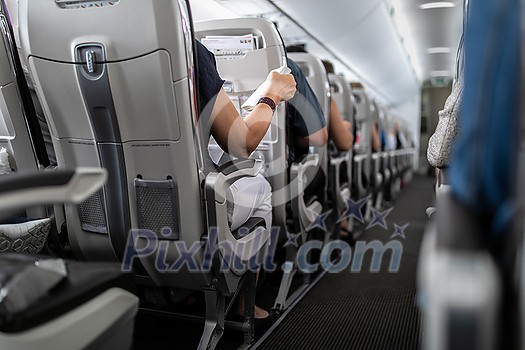 Interior of commercial airplane with passengers in their seats during flight.
