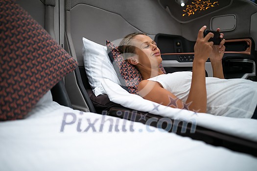 Pretty, young woman abord a first class commercial flight using their cell phone during flight Pretty, young woman abord a first class commercial flight using their cell phone during flight