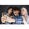 group of arab teens taking selfie photo on smart phone with black chalkboard in background