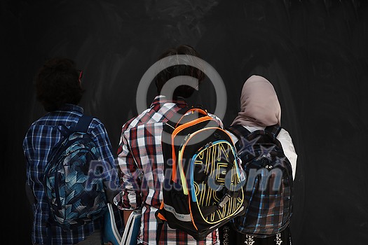 Arabic teenagers, students group  portrait against black chalkboard wearing backpack and books in school