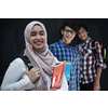 Arabic teenagers, students group  portrait against black chalkboard wearing backpack and books in school