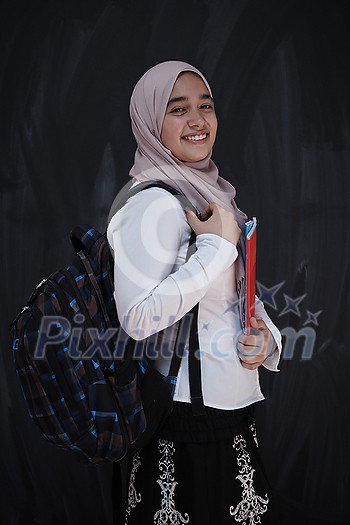 portrait of happy female middle eastern university student against black chalkboard in classroom portrait of happy female middle eastern university student against black chalkboard in classroom