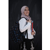 portrait of happy female middle eastern university student against black chalkboard in classroom