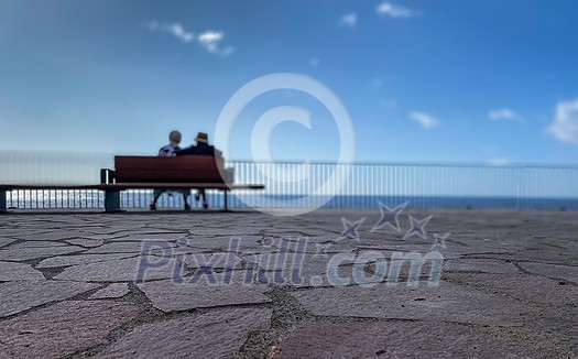 Old Age - Old couple sitting on a bench by the sea (shallow DOF)