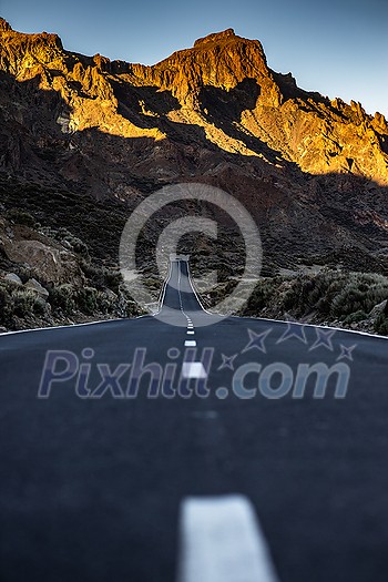 Long road in a mountain valley with a car on it - Teide National Park, Tenerife, Canary islands Long road in a mountain valley with a car on it - Teide National Park, Tenerife, Canary islands