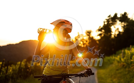 Pretty, young woman biking on a mountain bike enjoying healthy active lifestyle outdoors in summer (shallow DOF) Pretty, young woman biking on a mountain bike enjoying healthy active lifestyle outdoors in summer (shallow DOF)