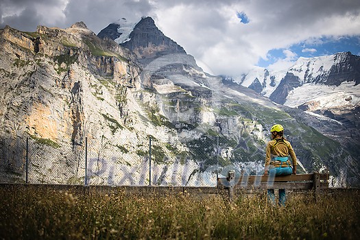 Pretty, female climber on a via ferrata - climbing on a rock in Swiss Alps Pretty, female climber on a via ferrata - climbing on a rock in Swiss Alps