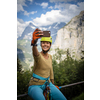 Pretty, female climber on a via ferrata - climbing on a rock in Swiss Alps