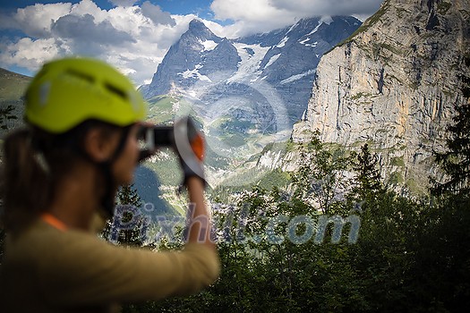 Pretty, female climber on a via ferrata - climbing on a rock in Swiss Alps Pretty, female climber on a via ferrata - climbing on a rock in Swiss Alps
