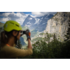 Pretty, female climber on a via ferrata - climbing on a rock in Swiss Alps