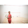 Pretty, female squash player on a squash court (motion blurred image; color toned image)