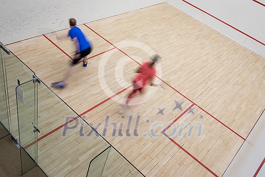 Squash players in action on a squash court (motion blurred image; color toned image) Squash players in action on a squash court (motion blurred image; color toned image)