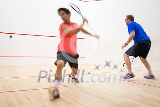 Squash players in action on a squash court (motion blurred image; color toned image) Squash players in action on a squash court (motion blurred image; color toned image)