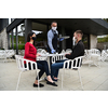 Waiter with protective medical mask and gloves serving guest with coffee at an outdoor bar caf or restaurant new normal concept reopening after quarantine