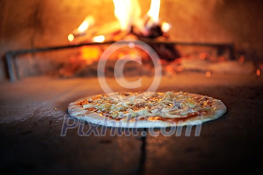 Rustic pizza is removing from hot stove where it was baked. Cook using special shovel to removing them. This restaurant have special wood fired oven Rustic pizza is removing from hot stove where it was baked. Cook using special shovel to removing them. This restaurant have special wood fired oven