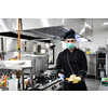 chef cook wearing face protective medical mask for protection from corona virus disease with plate of authentic sandwich at professional restaurant kitchen. Health, safety and pandemic concept in new normal concept