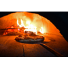 Rustic pizza is removing from hot stove where it was baked. Cook using special shovel to removing them. This restaurant have special wood fired oven