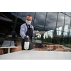 Waiter cleaning the table with Disinfectant Spray in a restaurant wearing protective medical mask and gloves new normal concept