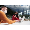 coronavirus outbreak Group of casual business People in outdoor restaurant wearing protective medical mask, business team collaborating and brainstorming business ideas  while working on laptop