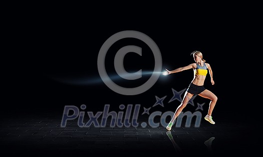 Young woman athlete running fast on dark background Young woman athlete running fast on dark background