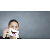 Pretty young girl holding white card with drawn smile showing tongue