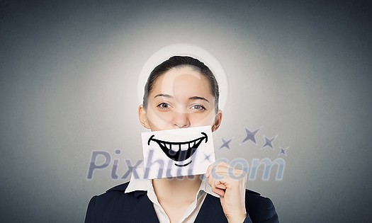 Pretty young girl holding white card with drawn smile with teeth
