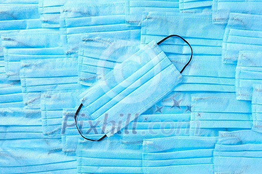 Medical antibacterial protective blue face masks on the same color background from masks. Concept of prevention from respiratory sickness and viruses. Medical antibacterial protective blue face masks on the same color background from masks. Concept of prevention from respiratory sickness and viruses.