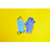 Things for prevention from respiratory sickness and viruses - two piles from medical protective masks and rubber gloves on a yellow background, copy space. Top view.