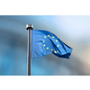 Waving flag of European Union on a blurred backgroud of parliament in Brussels, Belgium with copy space.