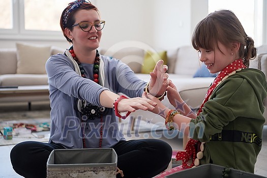 Mother and little girl daughter playing with jewelry while staying at home in coronavirus quarantine Mother and little girl daughter playing with jewelry while staying at home in coronavirus quarantine