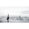 Back view of businesswoman standing on roof looking at city