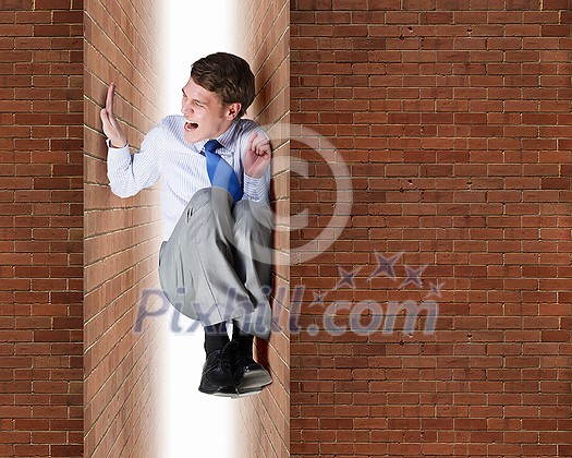 Businessman under pressure between two stone walls