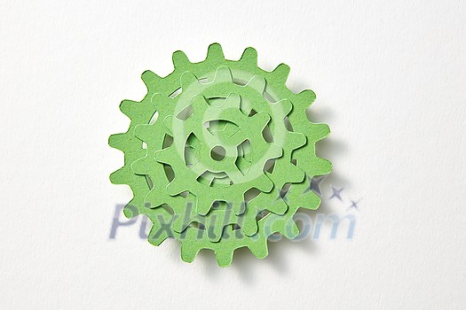 Handcarft set of machine gear from green color paper in the form of stack on a white background with soft shadows, copy space. Top view. Handcarft set of machine gear from green color paper in the form of stack on a white background with soft shadows, copy space. Top view.