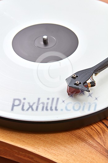 Old-fashioned vintage turnable record player with retro vinil disc on a wooden table, copy space. Popular disco trends 60s, 70s, 80s, 90s. Old-fashioned vintage turnable record player with retro vinil disc on a wooden table, copy space. Popular disco trends 60s, 70s, 80s, 90s.