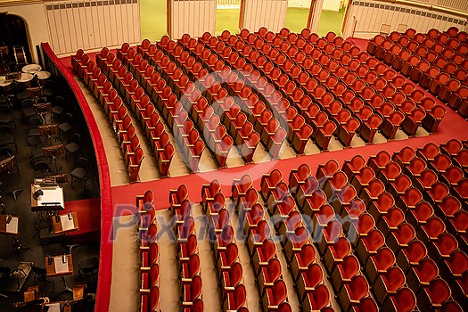 Wonderful view of the theatre concert hall of Vienna State Opera auditorium in Vienna, Austria - empty parterre with red seats in the rows without people and part of the orchestra pit. Wonderful view of the theatre concert hall of Vienna State Opera auditorium in Vienna, Austria - empty parterre with red seats in the rows without people and part of the orchestra pit.
