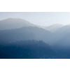 Beautiful tranquil landscape from blurred foggy mountains with trees on a background of sunny clear sky in Kufstein Austria.