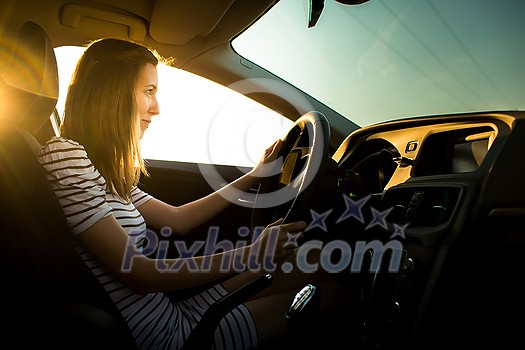 Driving a car at night - pretty, young woman driving her modern car (shallow DOF; color toned image) Driving a car at night - pretty, young woman driving her modern car (shallow DOF; color toned image)