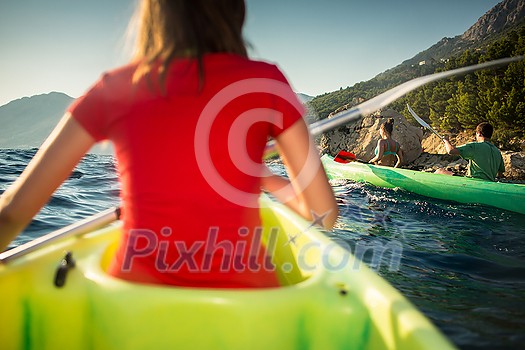 Group of friends sea kayaking on a sunny summer day Group of friends sea kayaking on a sunny summer day